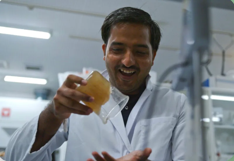 Narayan Lal Gurjar, fundador de EF Polymer, sostiene en el laboratorio un vaso con el gel de EF Polymer, que no se derrama al inclinarlo